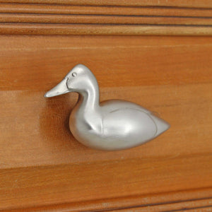 Left facing Canvasback duck knob installed on wood drawer - angled view