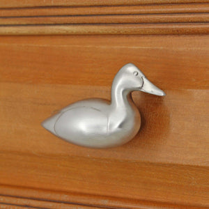 Right facing Canvasback duck knob installed on wood drawer - angled view