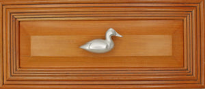 Right facing Canvasback duck knob installed on wood drawer - full view