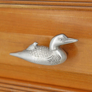Right facing Loon knob installed on wood drawer - angled view
