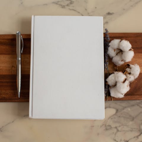 Photo by Monstera Production: https://www.pexels.com/photo/white-notebook-with-pen-and-cotton-flowers-on-tray-6373406/