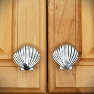 Set of matching Small seashell knobs installed on pair of cabinet doors