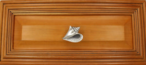 Right flange Conch shell knob on wood cabinet drawer - full view