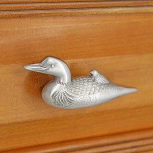 Left facing Loon knob installed on wood drawer - angled view
