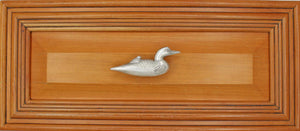 Right facing Loon knob installed on wood drawer - full view